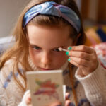 Meisje wat het oogschaduw palet 3 kleuren gebruikt.