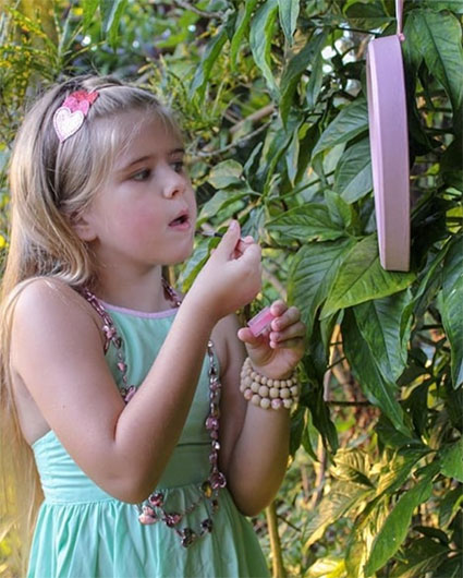 Op deze afbeelding zie je een meisje die in een spiegel kijkt en zelf haar eigen troepvrije make-up op doet van No Nasties kids